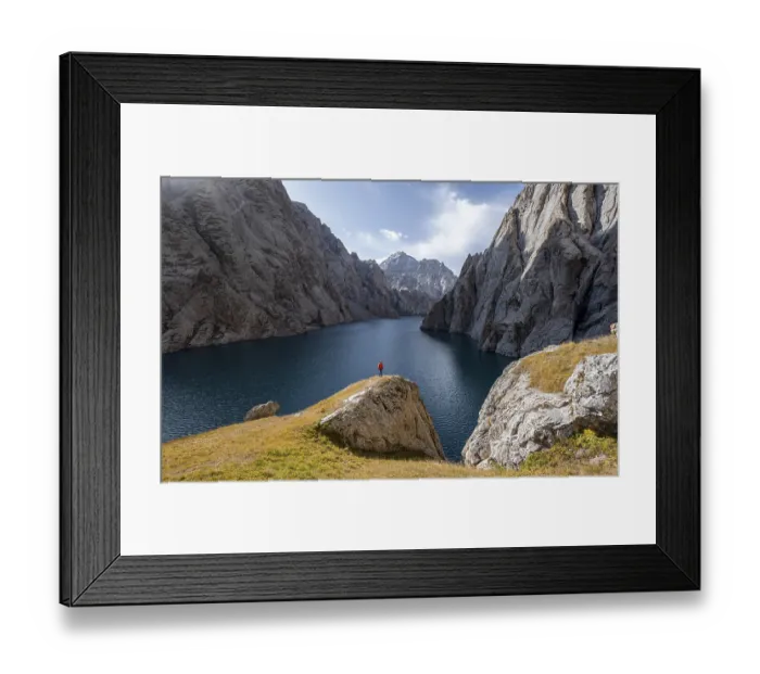 Framed Print : Tourist at the blue mountain lake between rocky steep mountain peaks
