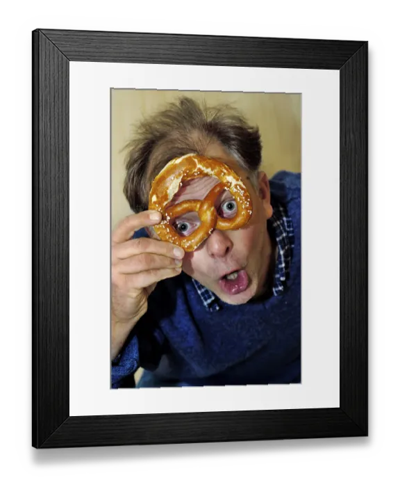 Framed Print : Man is looking astonished through a pretzel Framed Print : Man is looking astonished through a pretzel