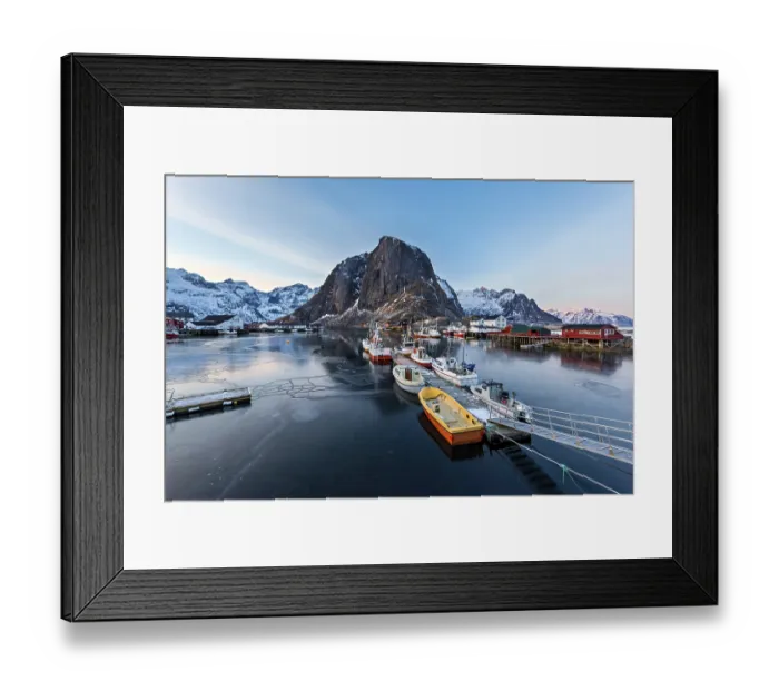 Framed Print : A fishing harbor with boats docked and mountain in the background at dawn