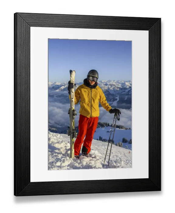 Framed Print : Skier standing at the ski slope holding ski