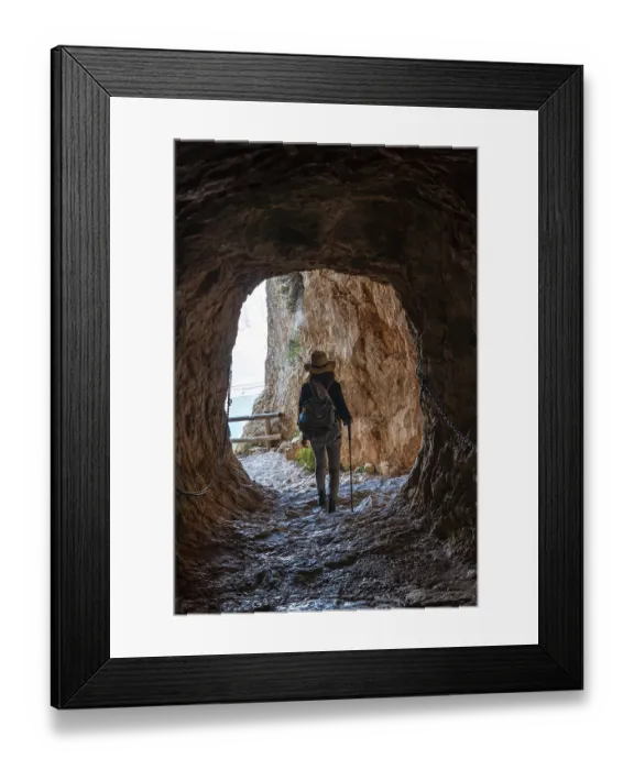 Framed Print : A young hiker in the tunnel of the trail in the Penon de Ifach Natural Park with the city of Calpe in the background Framed Print : A young hiker in the tunnel of the trail in the Penon de Ifach Natural Park with the city of Calpe in the background