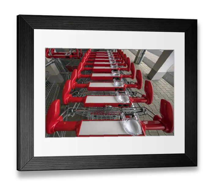 Framed Print : Shopping trolley with magnifying glass in front of a supermarket