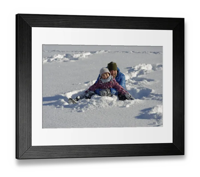 Framed Print : Father and daughter sitting in the deep snow