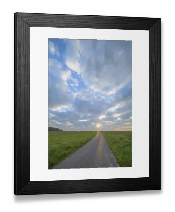 Framed Print : Meadow with road at sunrise