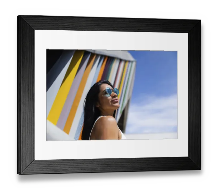 Framed Print : A stylish woman wearing a colorful outfit poses confidently against a backdrop of modern architecture Framed Print : A stylish woman wearing a colorful outfit poses confidently against a backdrop of modern architecture