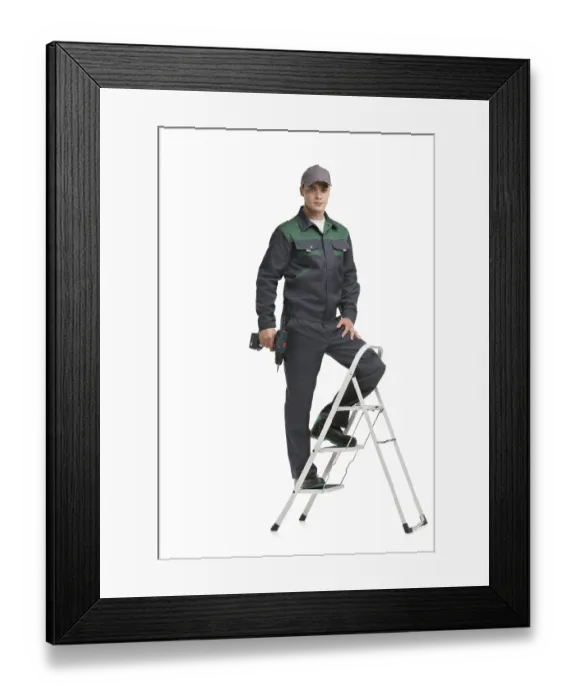Framed Print : Male in black and green work clothes and baseball cap with drill staying on ladder isolated full-length view