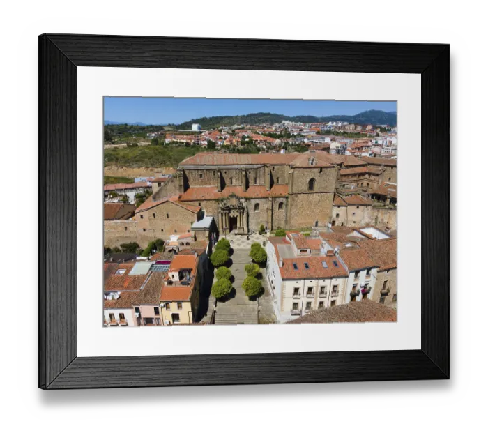 Framed Print : Large historic church with wide steps and surrounded by old buildings with red roofs in a hilly landscape