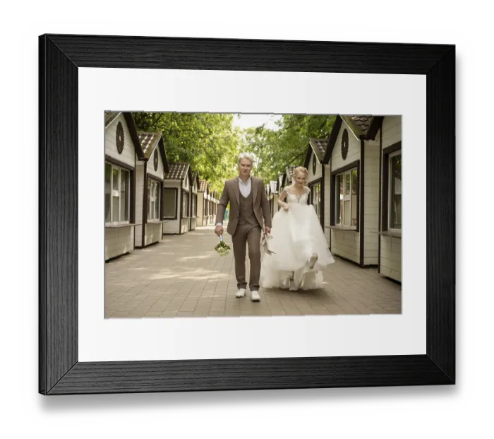 Framed Print : Happy couple strolls hand in hand in a charming outdoor setting surrounded by quaint structures