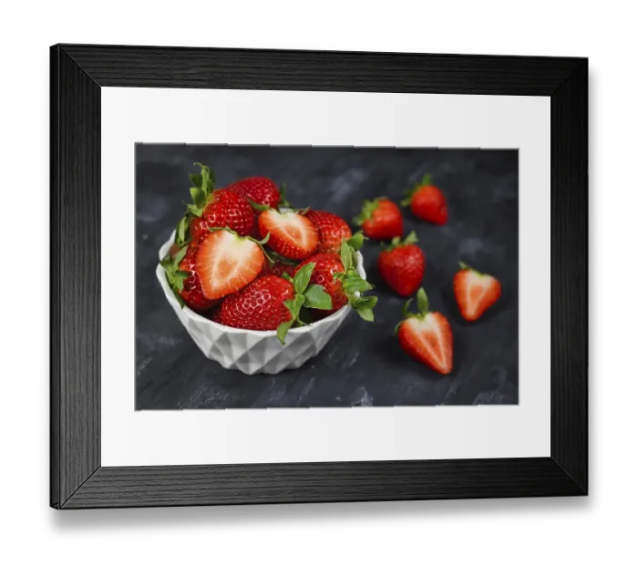 Framed Print : Strawberries in a bowl showing fresh ripe whole and cut in half strawberry fruits in a white bowl on dark background