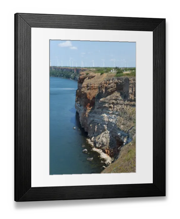 Framed Print : Erosion cliff with visible layers next to clear blue sea