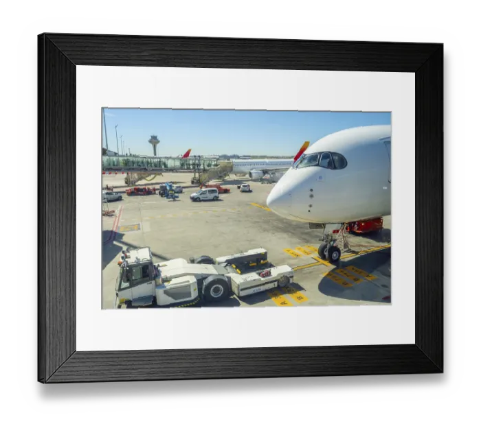 Framed Print : Airplane parked at an airport gate