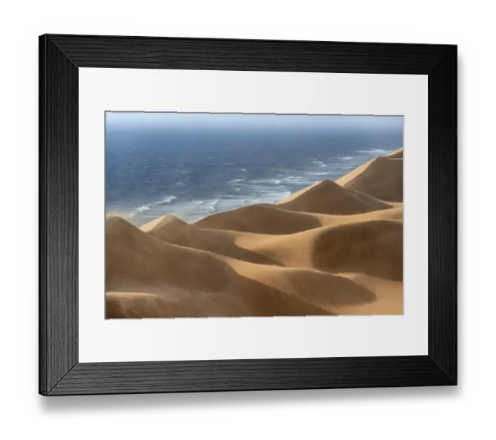 Framed Print : Sand dunes with wave patterns and sea in evening light