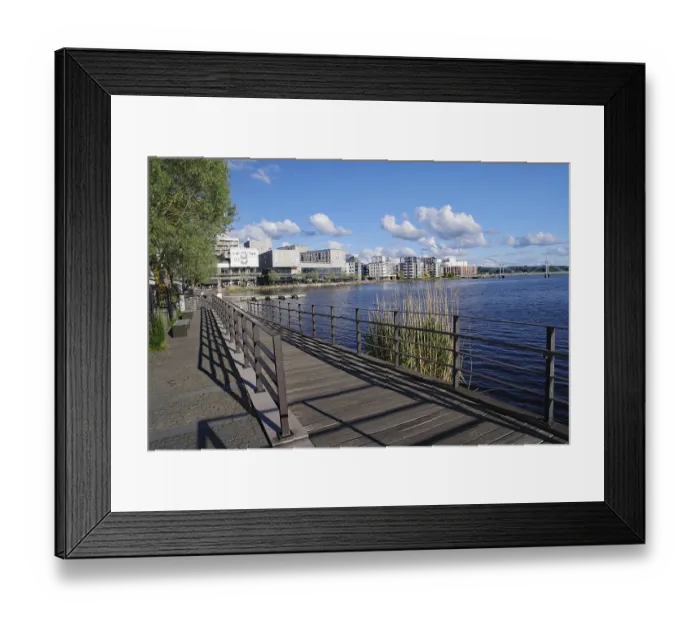 Framed Print : Footpath along a river with a view of modern buildings Framed Print : Footpath along a river with a view of modern buildings