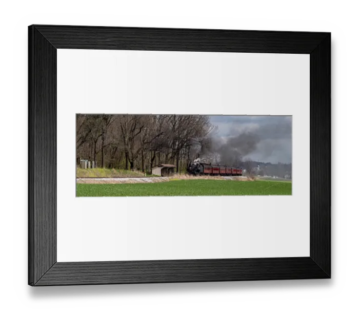 Framed Print : A vintage steam train releases smoke as it moves along the tracks Framed Print : A vintage steam train releases smoke as it moves along the tracks