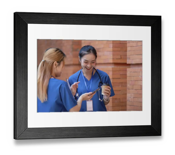 Framed Print : Two doctors in blue scrubs engage in a cheerful conversation during their break