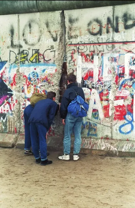 Framed Print : 12.11.1989 GDR Mitte district. Three young people look through a hole in the wall into the GDR