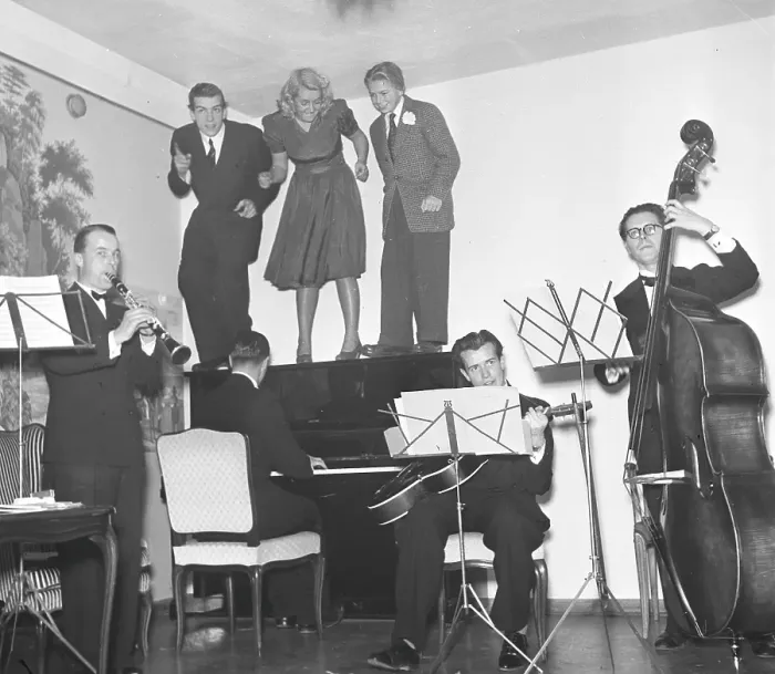 Framed Print : In the 1940s. A band with four musicians are playing while three people are standing on the piano, visibly moving to the swing music. Sweden 1943. Kristoffersson ref E23-2