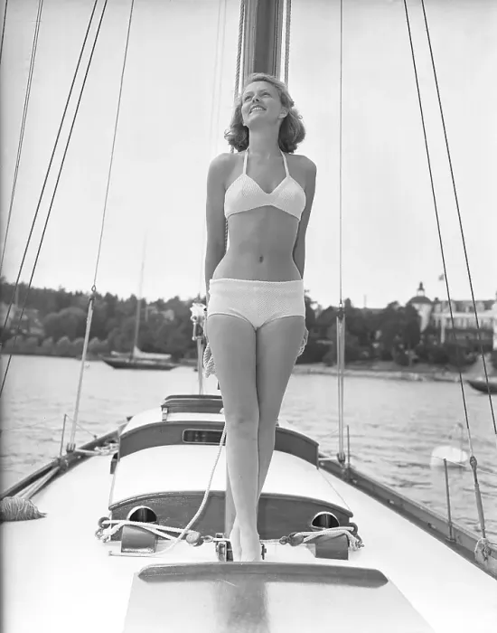 Framed Print : 1940s bikinifashion. A swedish young woman in a white bikini on a sailing boat on a summer's day