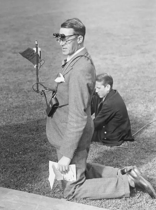 Framed Print : 1940s media man. A man is standing on his knees on the grass of the inner field of a sports stadium