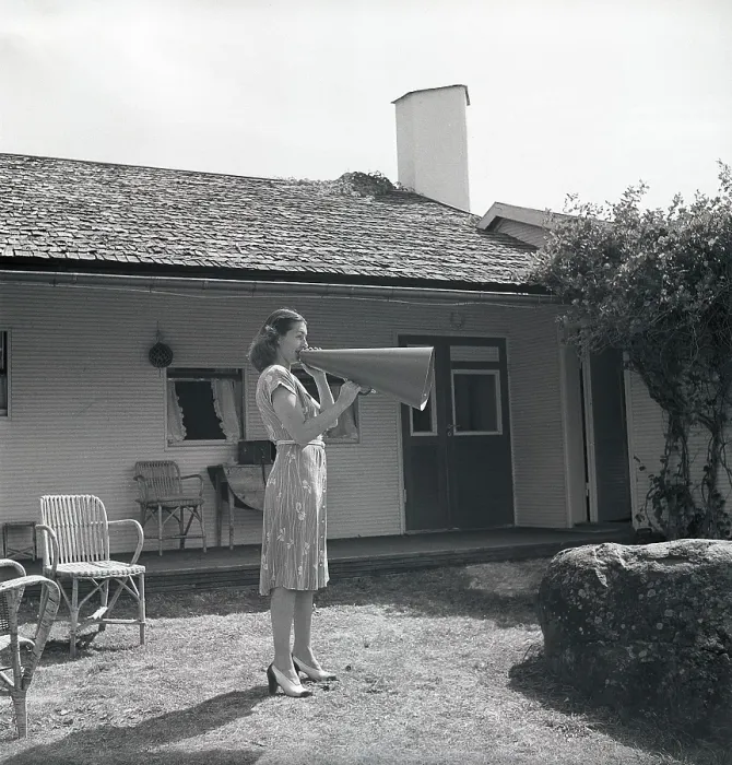 Framed Print : 1940s woman. To make herself heard better the young woman is yelling into a megaphone