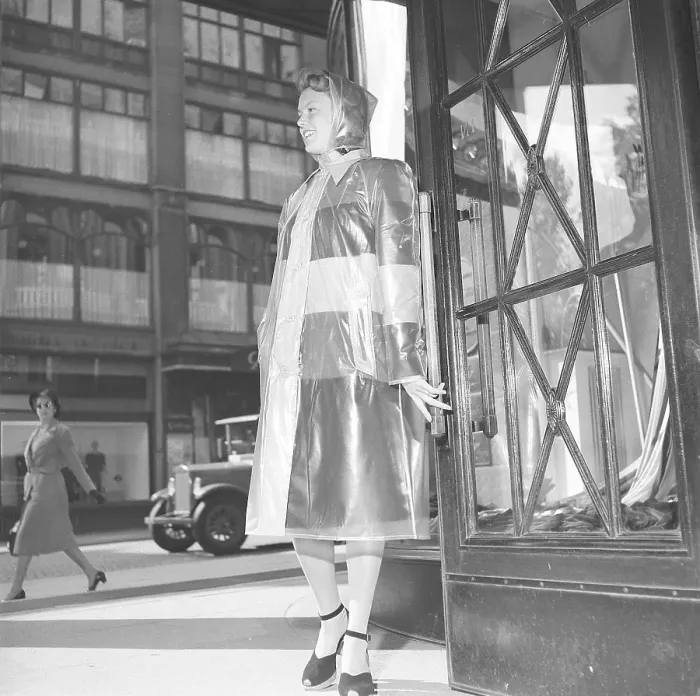 Framed Print : 1940s woman in raincoat. A young woman dressed in a raincoat of plastic material