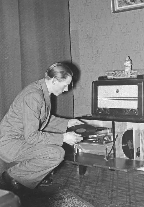 Framed Print : In the 1940s. World champion runner Gunder Haegg, 1918-2004, from Sweden pictured in his home while listening to music records on hthe gramophone. He also has a nice radio.1942