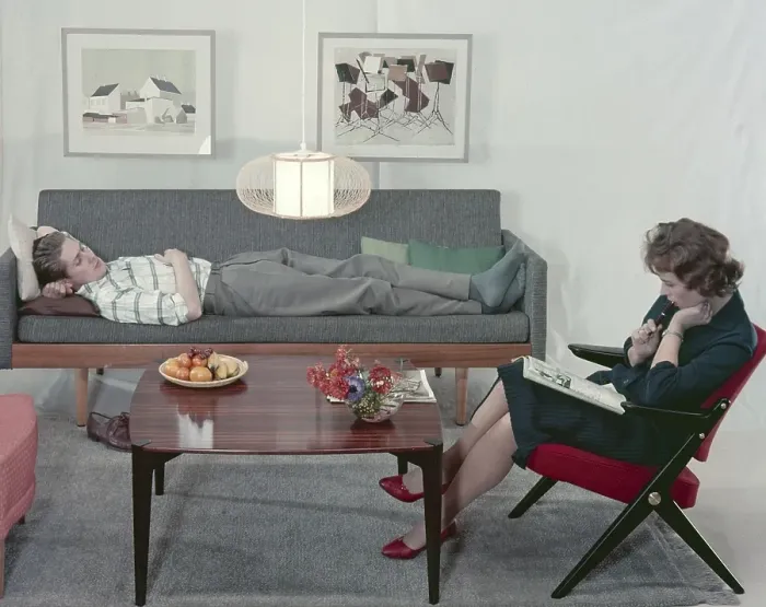 Framed Print : In the 1950s 1960s. A man and a women in a room with a couch and an armchair