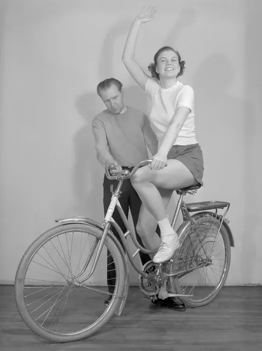 Framed Print : 1950s bicycle. A young women on a brand new bicycle for women