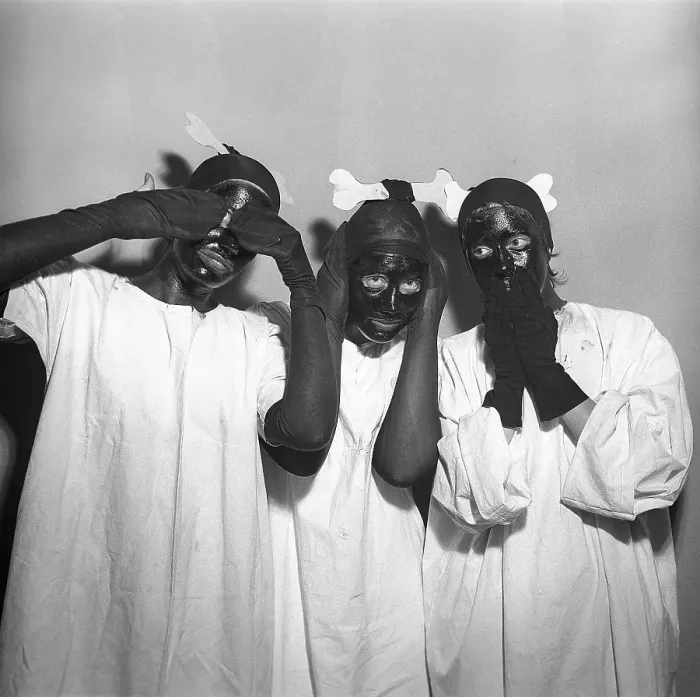 Framed Print : In the 1950s. Three girls in the same outfits have their faces painted in black