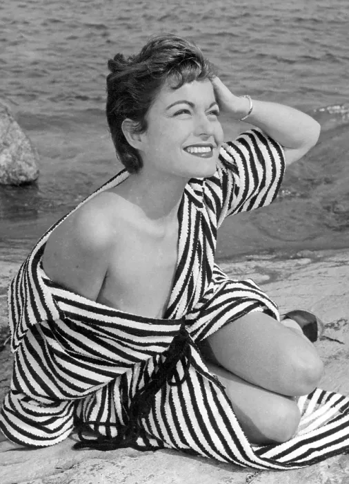 Framed Print : 1950s summer. A young woman wearing a stripe patterned bathrobe on the beach a sunny summer's day Framed Print : 1950s summer. A young woman wearing a stripe patterned bathrobe on the beach a sunny summer's day