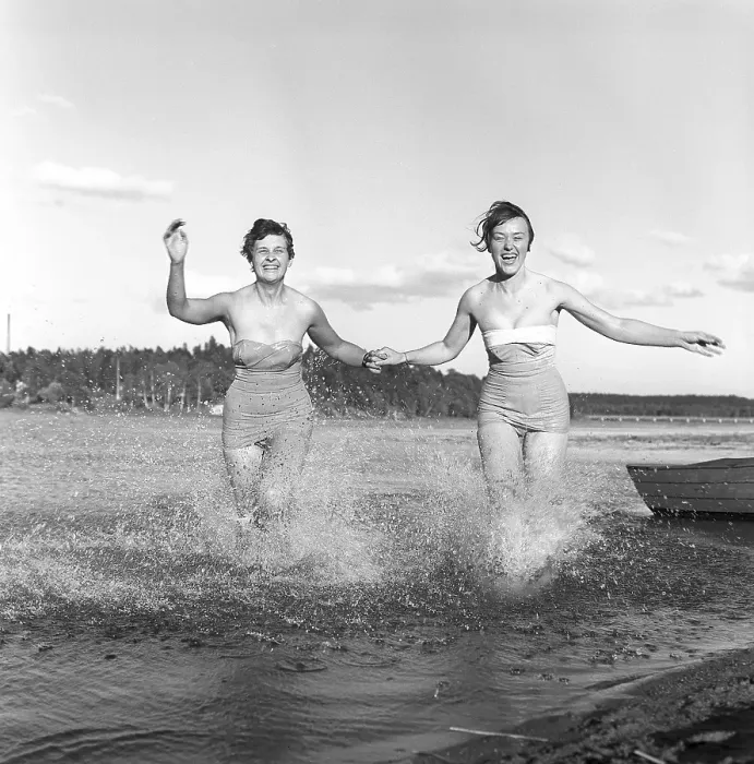Framed Print : 1950s summer. Two young women runs on the shallow part of the beach and the water splashes Framed Print : 1950s summer. Two young women runs on the shallow part of the beach and the water splashes