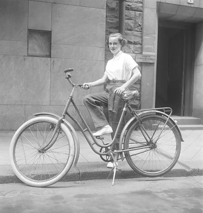 Framed Print : 1950s woman on a bicycle. A smiling young woman on a womens bicycle
