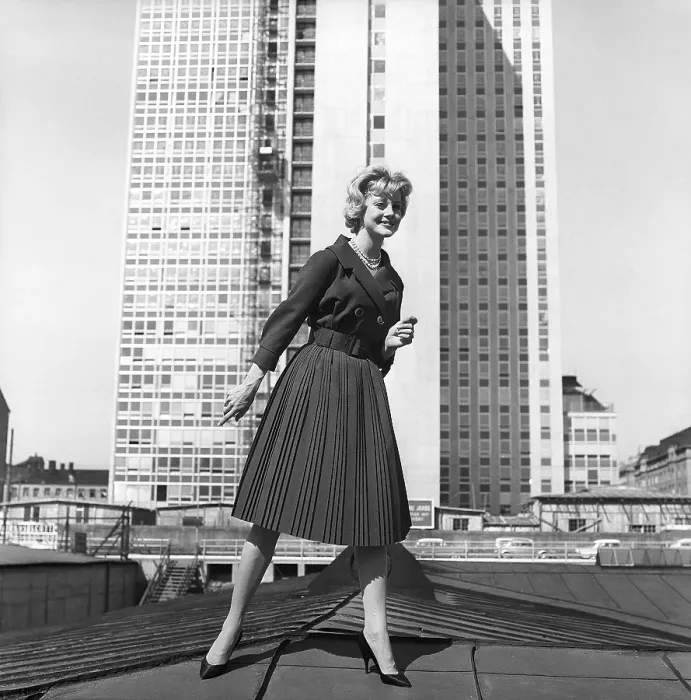 Framed Print : In the 1950s. A woman modelling a 1950s outfit with a jacket and skirt in matching dark