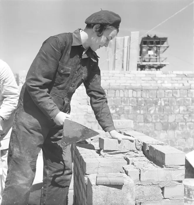 Framed Print : In the 1950s. Women construction worker is laying bricks on a building site Framed Print : In the 1950s. Women construction worker is laying bricks on a building site