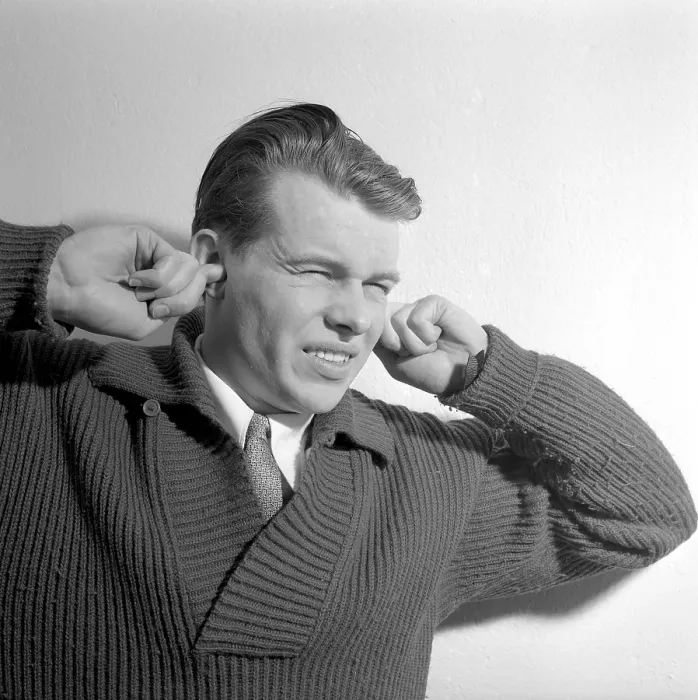 Framed Print : In the 1950s. A young man holds his hands over his ears