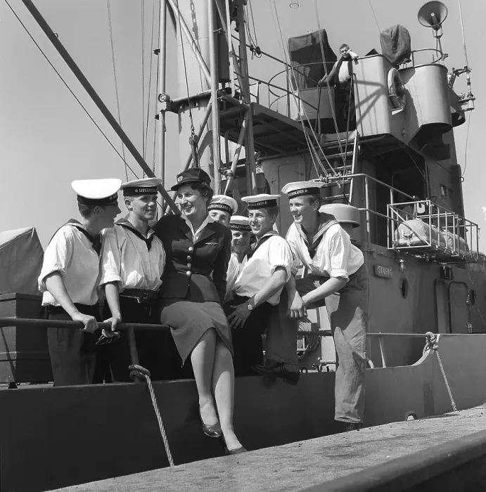Framed Print : In the 1950s. A young woman in uniform at the dock surrounded by sailors from the crew of the ship Sturkoe, which belongs to the Swedish Navy. The picture was taken in Visby on the island of Gotland, Sweden in 1959. Kristoffersson ref CG40-5