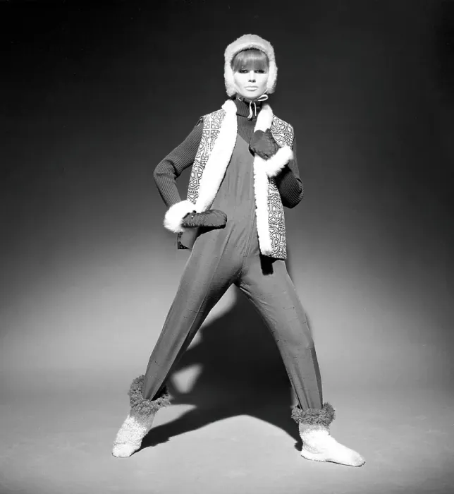 Framed Print : In the 1960s. A fashion model, in typical 1960s winter clothes in a studio. She has a thin overall on top over a knitted long sleeved sweater together with a vest, gloves and cap. Sweden 1966