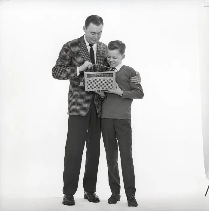 Framed Print : In the 1960s. Father and son with a radio