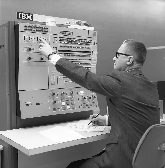 Framed Print : In the 1960s. Interior of a room with computers and people on the job of handling them and register and reading information. A sign above the mainframe computer says IBM 360