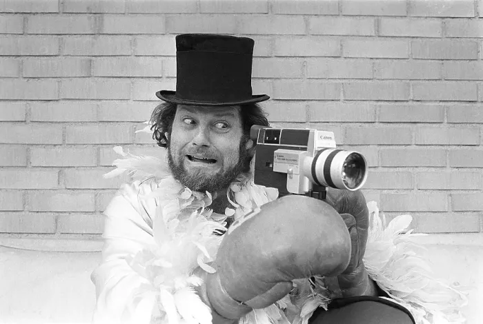 Framed Print : In the 1970s. A man is filming with a amateur film camera. The film was then developed and shown on a film projector on a fold up screen at home. Ricky Bruch (1946-2011) Swedish track and field athlete