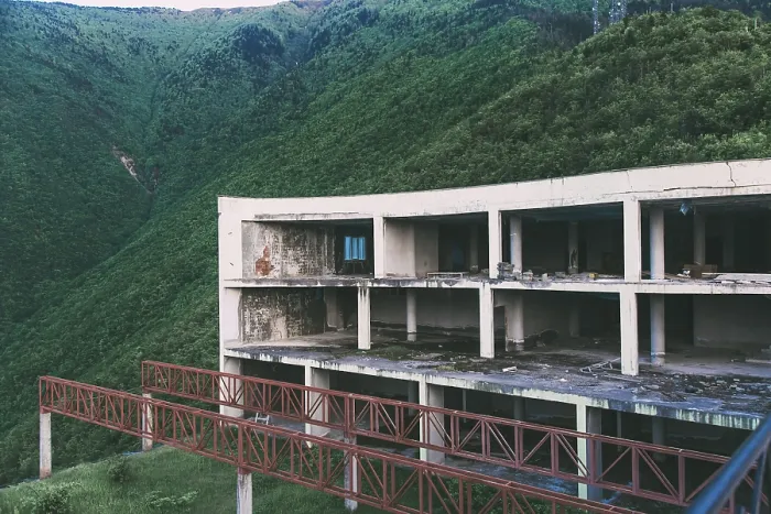 Framed Print : Abandoned building in the mountains with a red bridge leading to it