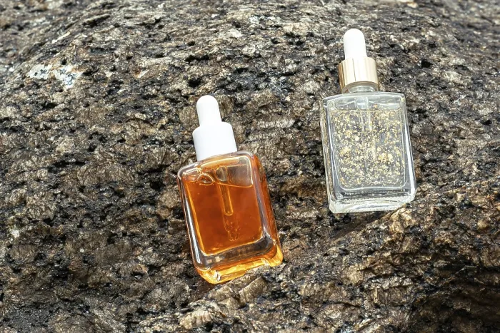 Framed Print : From above, two cosmetic serums enriched with vitamins and golden flakes rest on a rugged