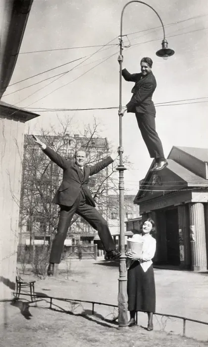 Framed Print : Acrobatic in the 1930s. Two men are haning in a lamp post by their hands and feet