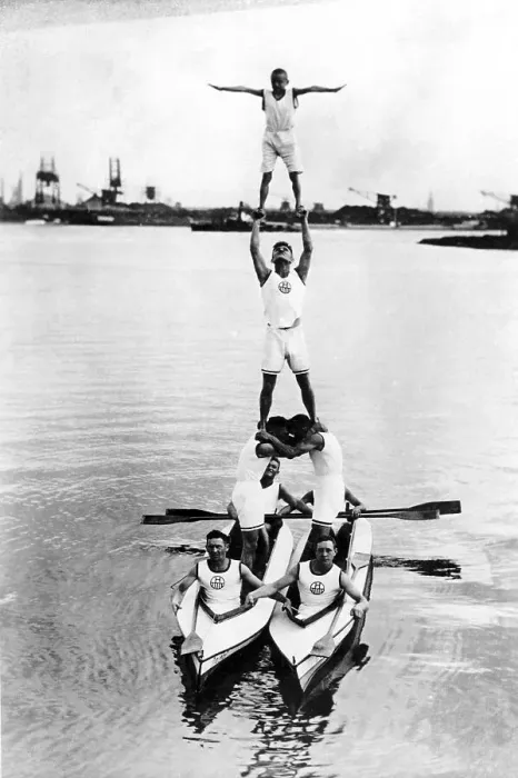 Framed Print : Acrobats build a pyramid on two rowing boats in the water