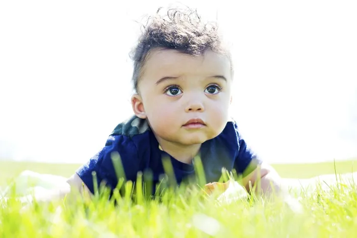 Framed Print : Adorable baby boy outdoors posing on green grass
