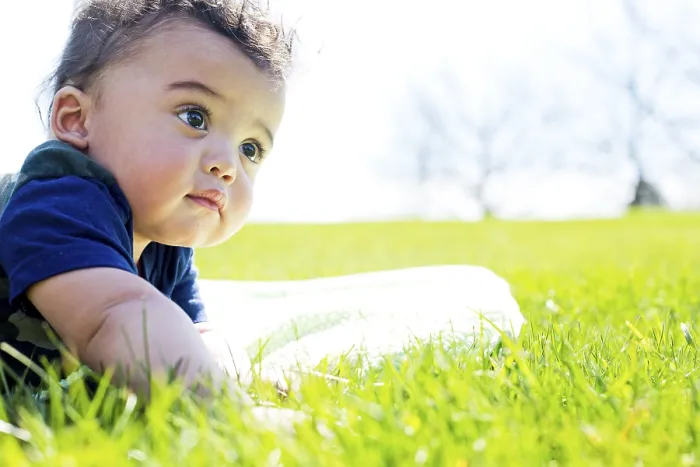 Framed Print : Adorable baby boy outdoors posing on green grass