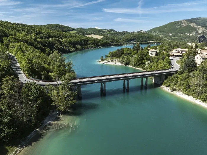 Framed Print : Aerial view of a bridge spanning the vibrant turquoise waters of Lago di Fiastra
