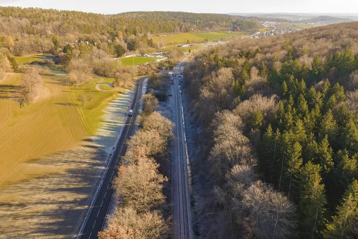 Framed Print : Aerial view of a railway line between trees and a road in a rural area