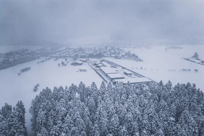 Framed Print : Aerial view of a snowy village surrounded by forests