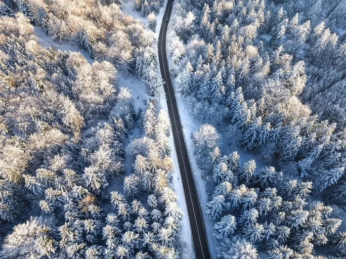 Framed Print : Aerial view of a snowy, winding road through a coniferous forest in winter Framed Print : Aerial view of a snowy, winding road through a coniferous forest in winter